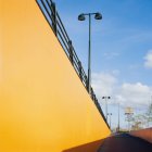 Желтая цветная стена на солнце и дороге — стоковое фото