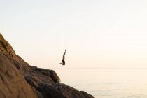 Young man jumping into lake, kingdom of sweden — Stock Photo