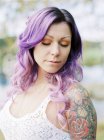 Retrato de novia con pelo largo morado y tatuaje en la boda hippie - foto de stock