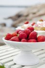 Strawberries in white fruit bowl on table — Stock Photo