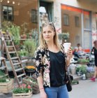 Mulher loira com xícara de café na rua da cidade — Fotografia de Stock