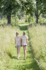View of two girls in footpath, rear view — Stock Photo