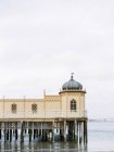 Wooden Bathhouse on sea with overcast sky on background — Stock Photo