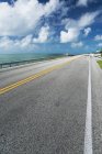 Route asphaltée marquée passant à côté du rivage océanique — Photo de stock