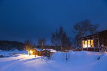 Granges et maison résidentielle dans un paysage enneigé la nuit — Photo de stock