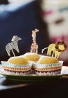 Plate of muffins decorated with animals on sticks — Stock Photo