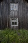 Фасад старого деревянного дома с высокой травой — стоковое фото