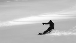 Seitenansicht eines Mannes beim Snowboarden in den französischen Alpen — Stockfoto