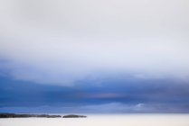 Larga exposición tiro de agua del lago bajo el cielo nublado - foto de stock