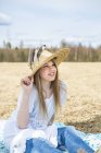 Портрет девушки в соломенной шляпе, фокус на переднем плане — стоковое фото