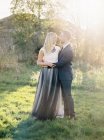 Sposo e sposa in piedi insieme in erba, messa a fuoco selettiva — Foto stock