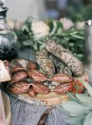 Salsichas de carne italiana em tábua de corte de madeira — Fotografia de Stock