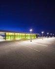 Empty parking lot and building illuminated at night — Stock Photo