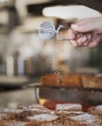 Persona setacciando zucchero a velo su torte — Foto stock