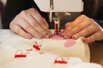 Gros plan sur les coutures de fille sur la machine à coudre — Photo de stock