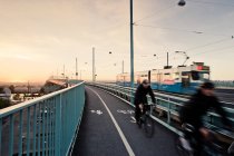 Homens andando de bicicleta na ponte, movimento turvo — Fotografia de Stock