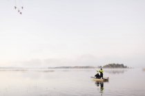 Giovani uomini che pescano nel lago al tramonto — Foto stock