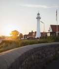 Вид на маяк и дома при вечернем солнечном свете — стоковое фото