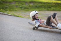Мальчик скользит по улице на скейтборде — стоковое фото
