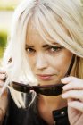Blonde woman taking sunglasses off, selective focus — Stock Photo