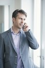Mature businessman in formal wear talking on mobile phone — Stock Photo