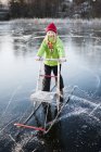 Girl with sleigh on frozen lake — Stock Photo