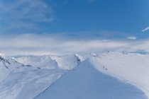 Vista panoramica sulle montagne innevate con escursionisti lontani — Foto stock