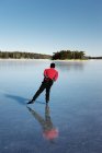 Вид ззаду людини катається на льоду на замерзлому озері — стокове фото