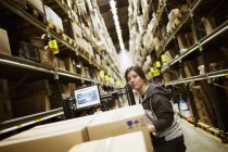 Young woman working in warehouse, differential focus — Stock Photo