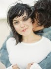 Freund umarmt und küsst Freundin, Fokus auf Vordergrund — Stockfoto