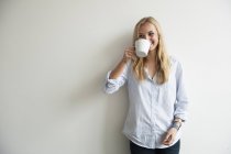 Studio shot of woman drinking coffee — Stock Photo