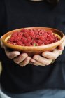 Front view of woman holding bowl of raspberries — Stock Photo