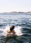 Visão traseira do homem nadando no lago — Fotografia de Stock