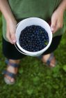 Boy holding bucket with fresh blueberries — Stock Photo