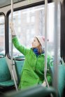 Молода жінка натискає кнопку зупинки запиту в трамваї — стокове фото