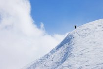 Pico de montanha coberto de neve com caminhante distante — Fotografia de Stock