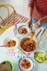 Femme mettant des spaghettis aux boulettes de viande maison en sauce tomate sur des assiettes — Photo de stock