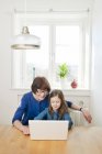 Portrait of grandmother and granddaughter using laptop — Stock Photo