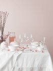 Set table decorated with blooming sakura branchlets — Stock Photo