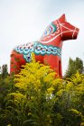 Escultura de cavalo de madeira ornamentada sobre arbustos — Fotografia de Stock
