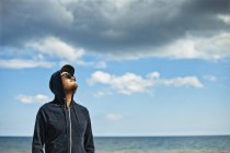 Портрет человека в капюшоне, смотрящего на небо — стоковое фото