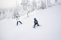 Мужчина и мальчик катаются на лыжах по склону, избирательный фокус — стоковое фото