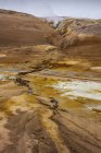 Vapor sobre fontes termais entre montanhas rochosas na Islândia — Fotografia de Stock