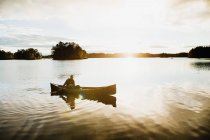 Mann paddelt Kanu auf See, Königreich Schweden — Stockfoto