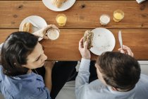 Пара їсть сніданок за столом, фокус на фоні — стокове фото