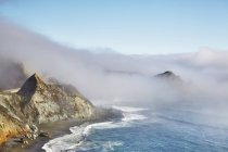 Scogliere costiere coperte da nuvole basse e nebbia — Foto stock