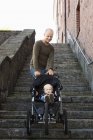 Папа толкает коляску с маленьким сыном, уменьшая перспективы — стоковое фото