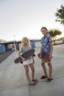 Хлопчик і дівчинка зі скейтбордами, що стоять на вулиці — стокове фото