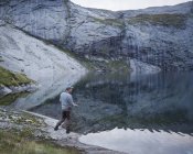 Вид сбоку на человека, ловящего рыбу в озере Fjerddalsvatnet — стоковое фото