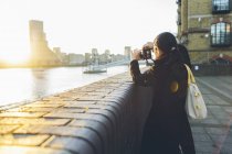 Donna adulta che scatta foto alla riva del fiume a Rotherhithe — Foto stock